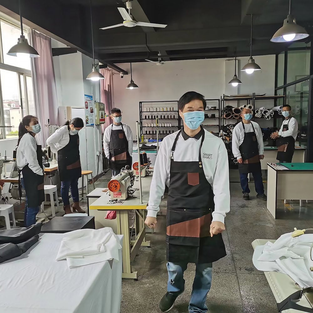 A group of people wearing masks in a factory.